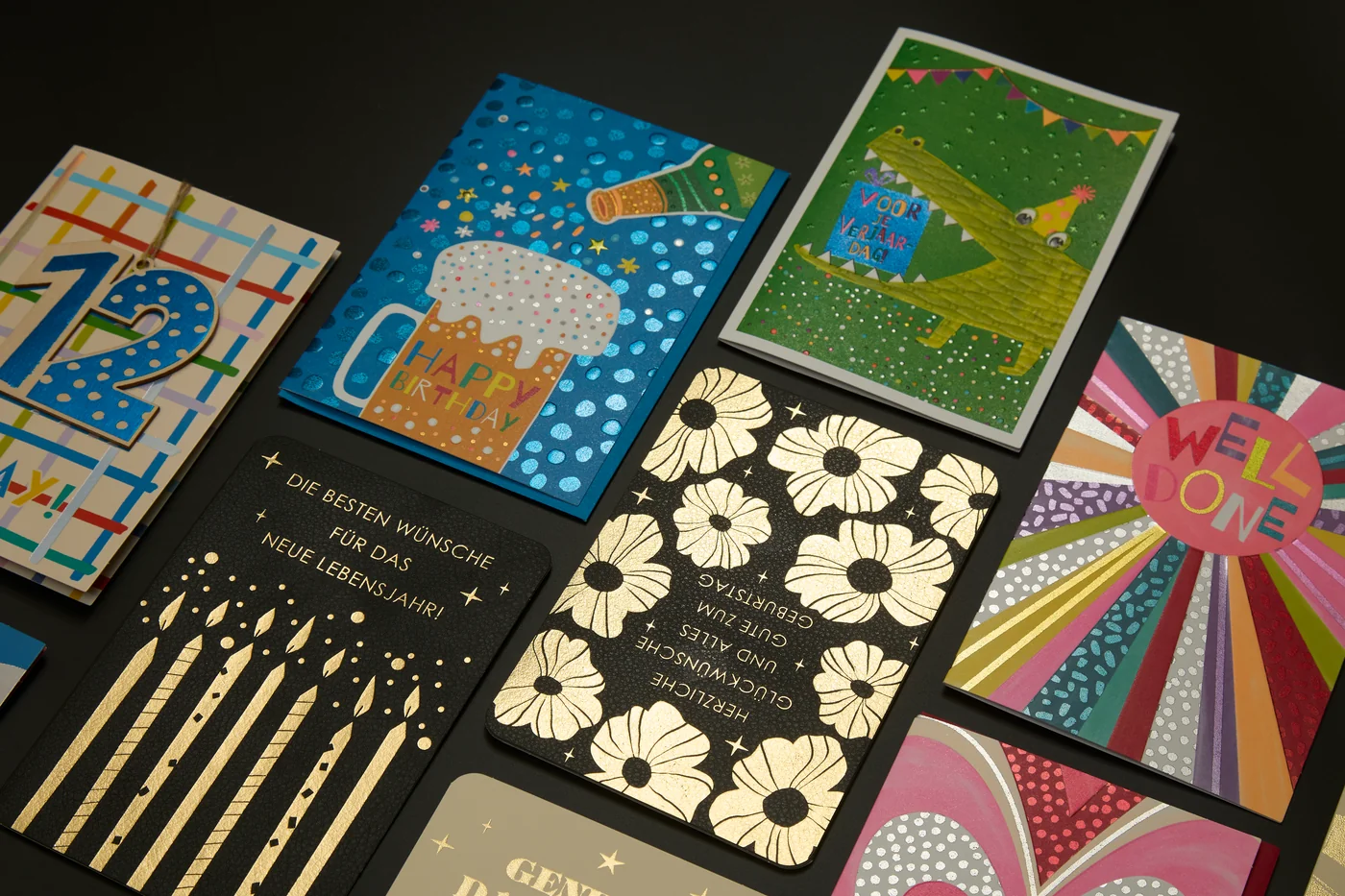 An assortment of greeting cards with floral, candle and colourful decorative designs