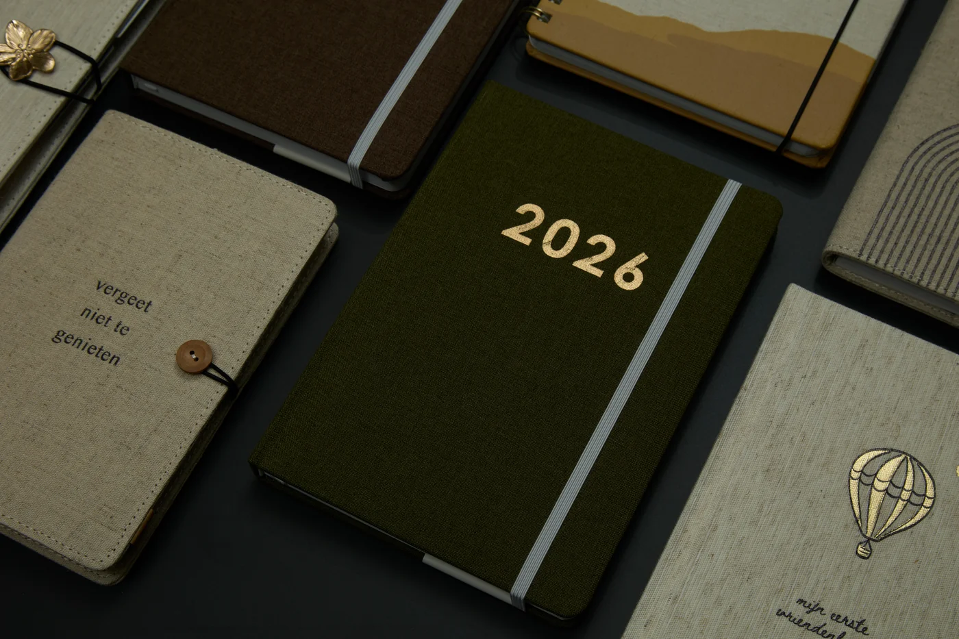 Close-up of textured notebook covers, elastic bands and closures